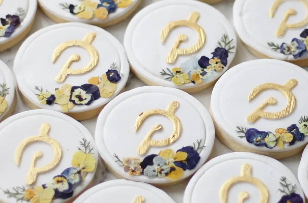 White fondant cookies with Peloton logo and flowers