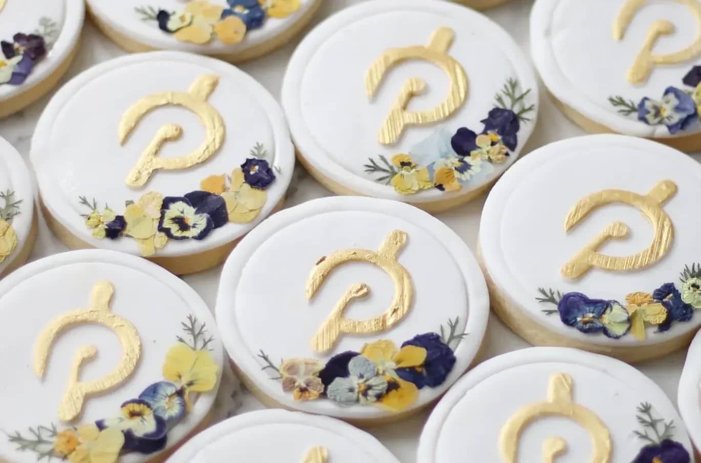 White fondant cookies with Peloton logo and flowers
